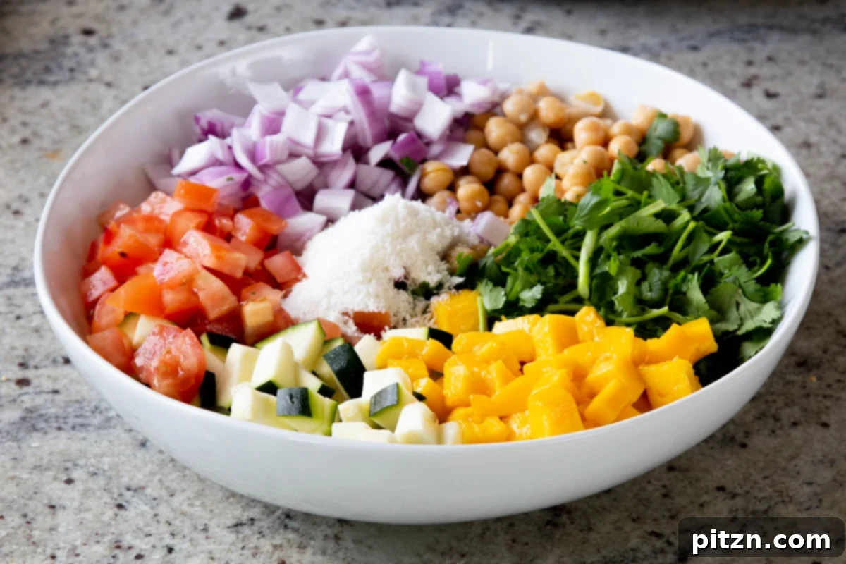 Fragrant Curry Leaf Mango Chickpea Zucchini Koshimbir 12 Sweet mango cubes, fresh cilantro, and shredded coconut already mixed into the salad bowl, adding tropical flavors and texture.