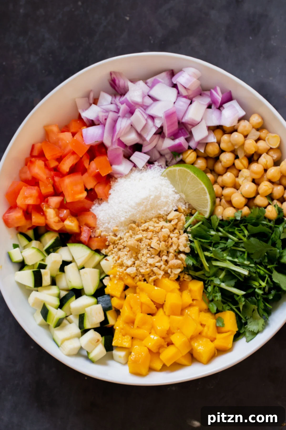Fragrant Curry Leaf Mango Chickpea Zucchini Koshimbir 3 A top-down view of all the vibrant, fresh ingredients for Koshimbir salad, meticulously chopped and arranged in a large bowl before mixing.