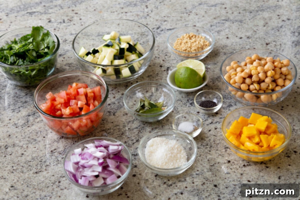 Fragrant Curry Leaf Mango Chickpea Zucchini Koshimbir 6 A beautiful spread of fresh vegetables, fruit, chickpeas, and seasonings artfully arranged in individual bowls on a clean kitchen counter, highlighting the raw ingredients.