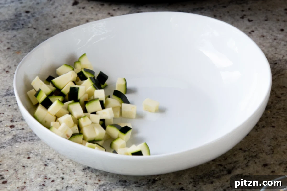 Fragrant Curry Leaf Mango Chickpea Zucchini Koshimbir 8 A bowl filled with freshly chopped zucchini, glistening and ready to be added to the Koshimbir salad.