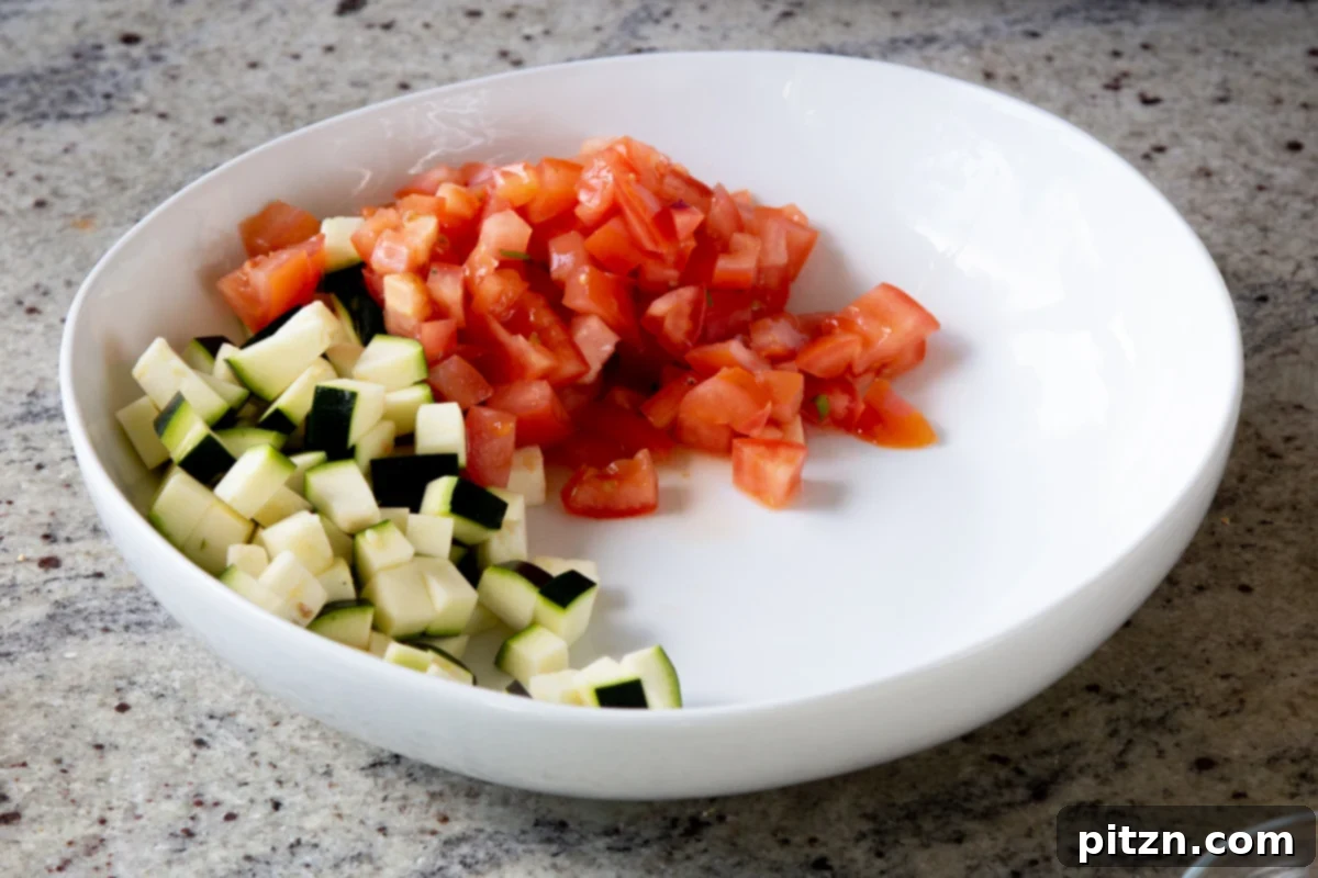 Fragrant Curry Leaf Mango Chickpea Zucchini Koshimbir 9 Freshly chopped tomatoes being added to a large salad bowl, contributing color and juiciness to the Koshimbir.