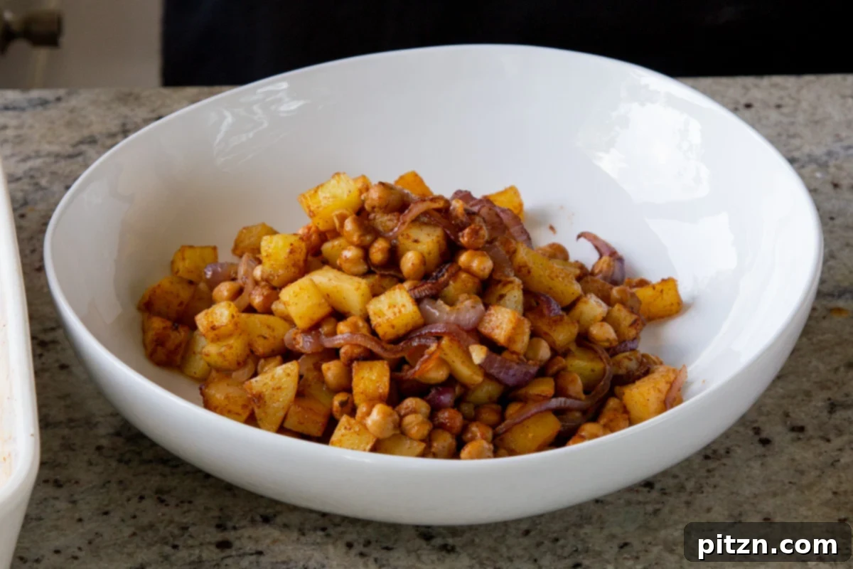 Smoky Chickpea Potato Salad 11 Roasted chickpeas, onions, and potatoes, golden and tender, transferred to a serving bowl after baking, cooling before final assembly.