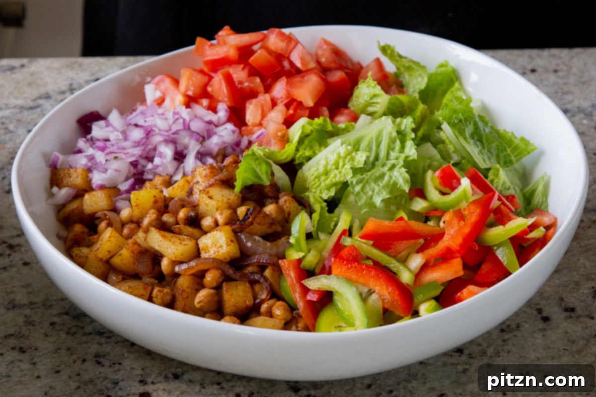 Smoky Chickpea Potato Salad 17 Sliced red onion being added to the salad bowl, providing a sharp, fresh contrast to the roasted elements.