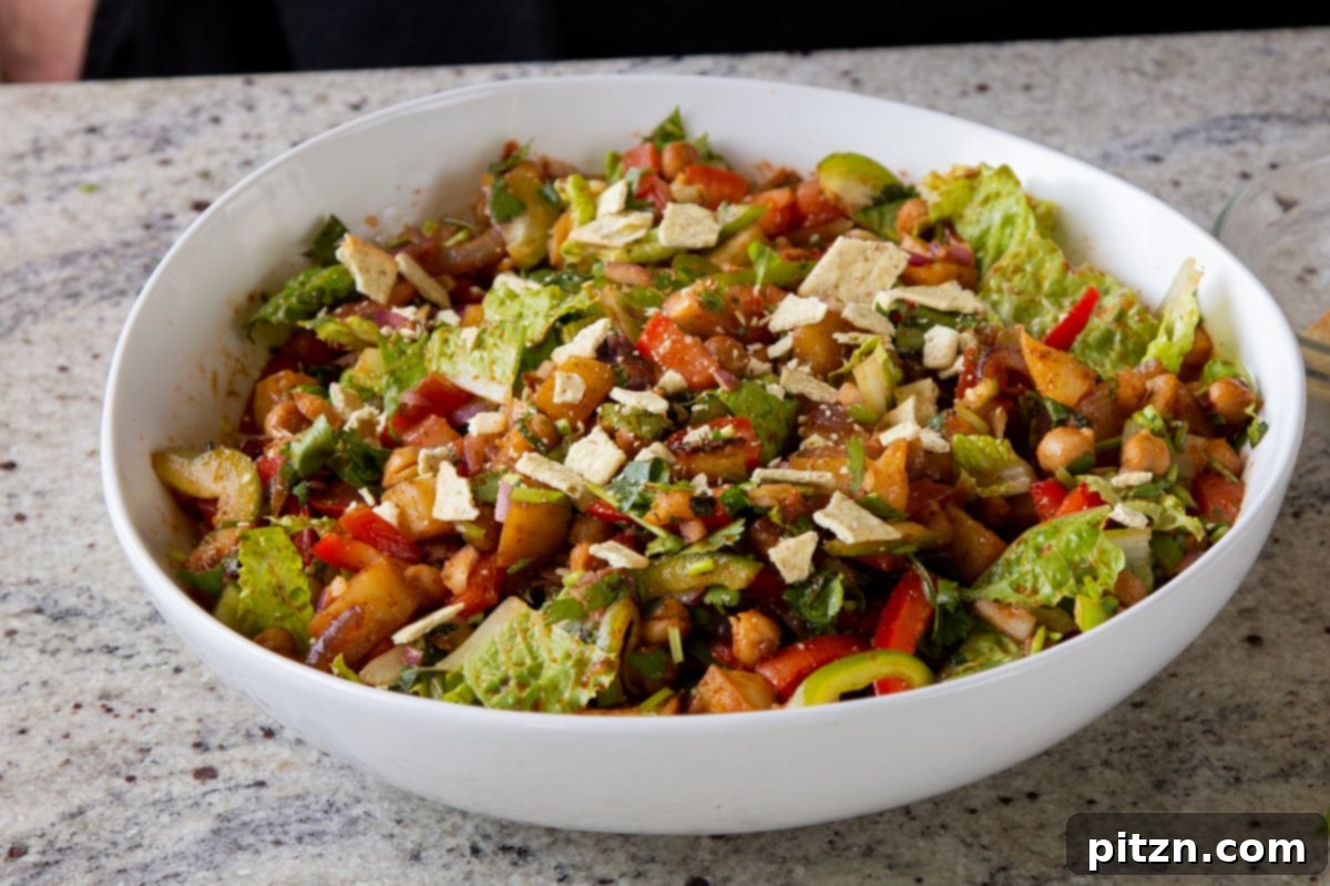 Smoky Chickpea Potato Salad 19 A vibrant and fully assembled BBQ chickpea and potato salad in a large serving bowl, garnished and ready to be enjoyed.