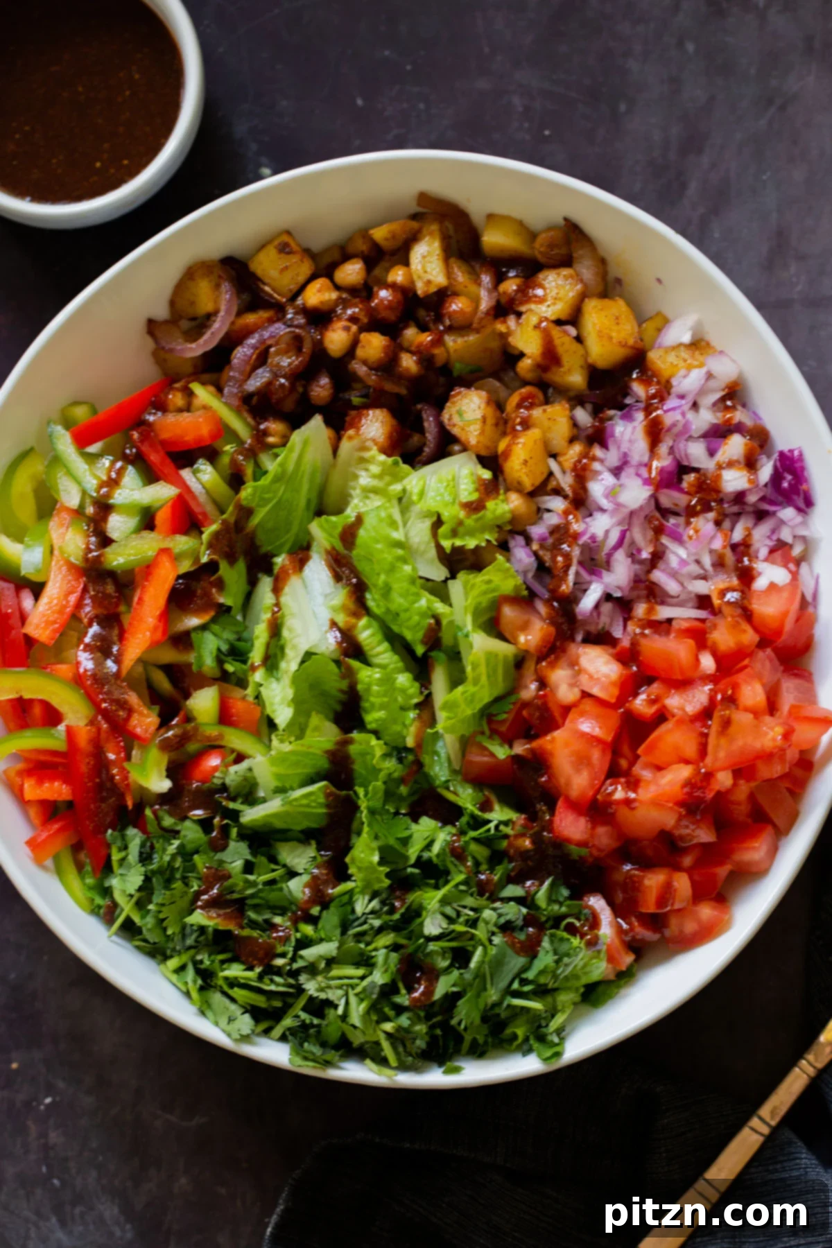 Smoky Chickpea Potato Salad 3 Fresh, crunchy vegetables like lettuce, tomatoes, and red onion await mixing in a large salad bowl, ready for the roasted chickpeas and potatoes.