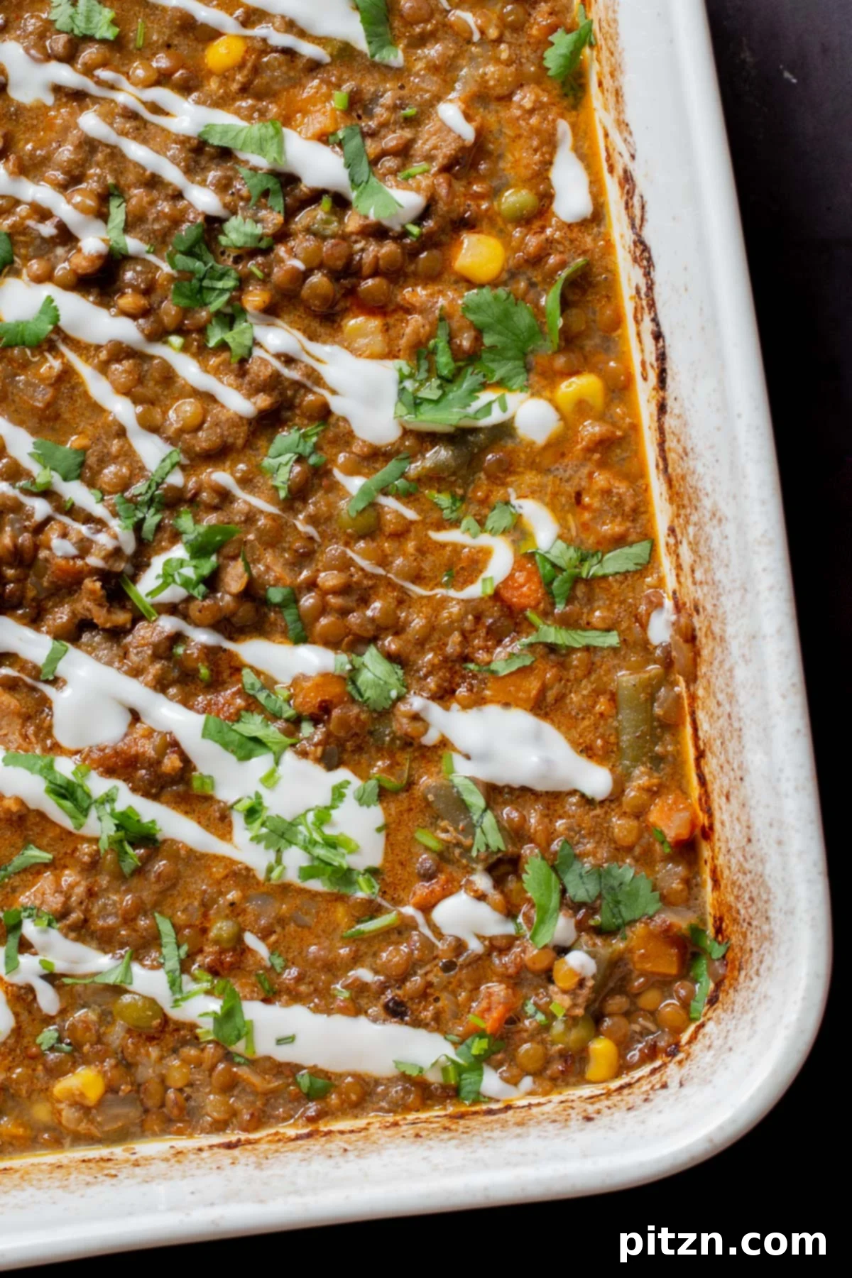 Sheet Pan Konkani Lentil Curry 3 close-up of baked Konkani curry dal topped with coconut cream, cilantro, and pepper flakes in the baking pan