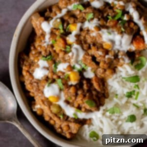 bowl of baked Konkani curry topped with coconut cream, cilantro, and pepper flakes