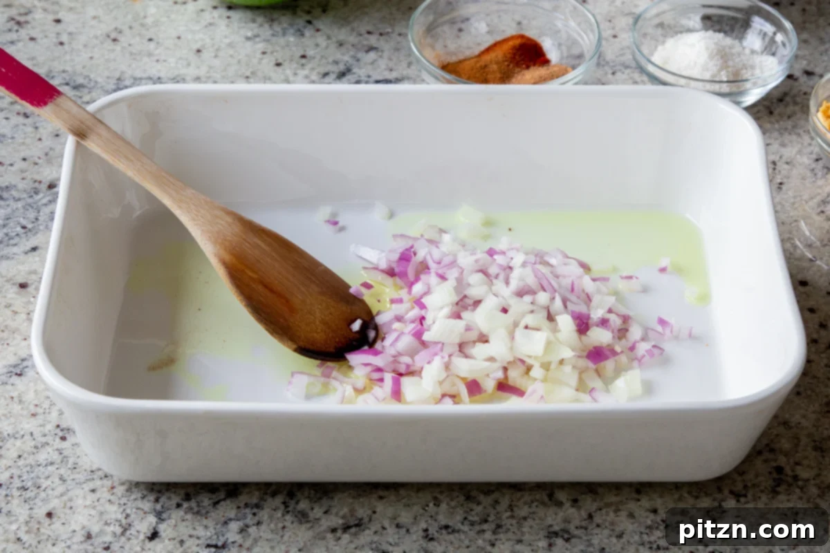 Sheet Pan Konkani Lentil Curry 7 adding onion, ginger, and garlic to the baking pan