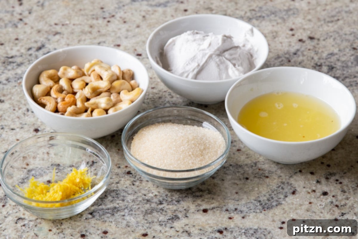 Bowls of raw cashews, thick coconut cream, fresh lemons, and other key ingredients for vegan lemon pudding arranged neatly on a kitchen countertop.