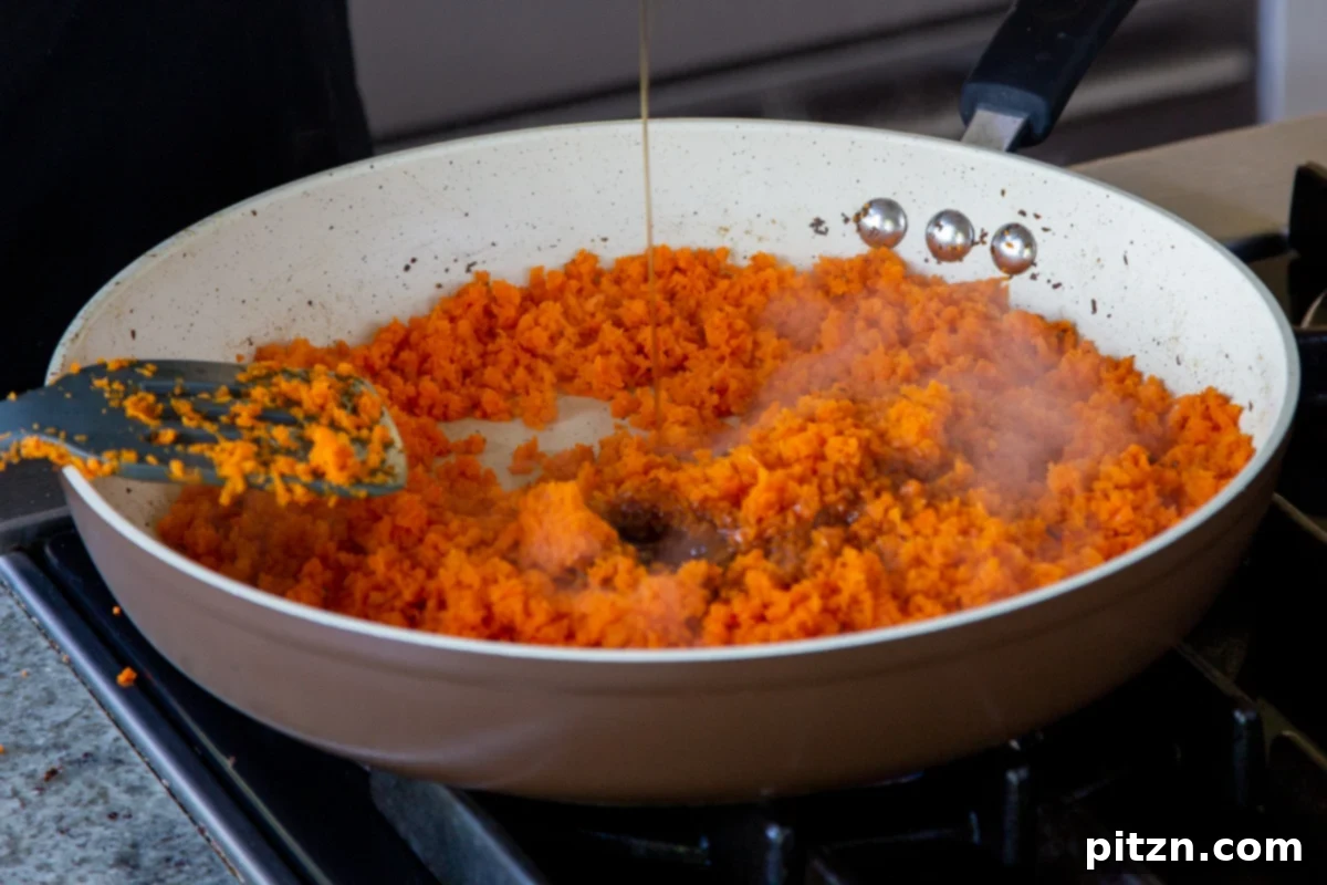 Indian Fusion Grain Free No Bake Carrot Halwa Cheesecake 10 adding maple syrup to the pan of grated carrots