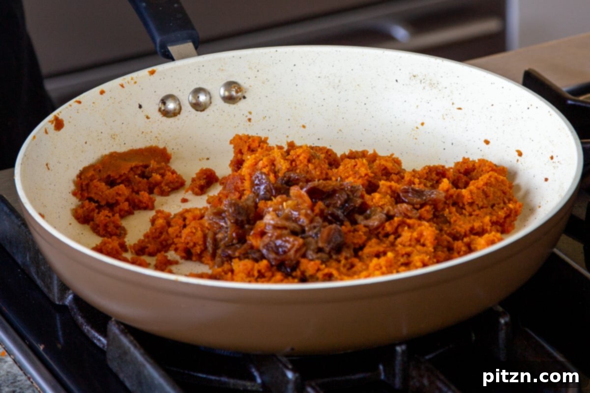 Indian Fusion Grain Free No Bake Carrot Halwa Cheesecake 12 adding raisins and flax meal to the pan of grated carrots