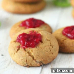 Cranberry thumbprint cookies on a wooden work surface