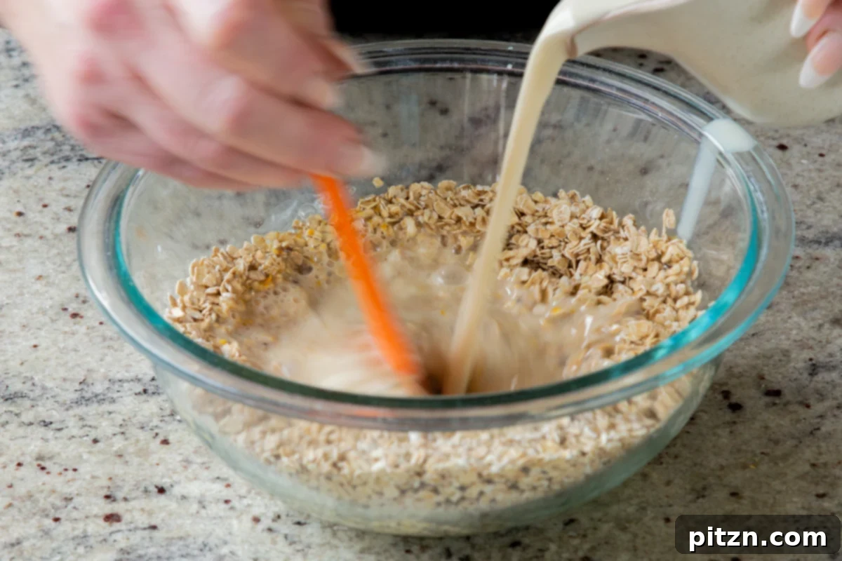 Easy Cannoli Overnight Oats: 30-Minute, Gluten-Free & Soy-Free 12 Hot non-dairy milk being poured into the glass bowl with the oat, chia seed, yogurt, and orange zest mixture.