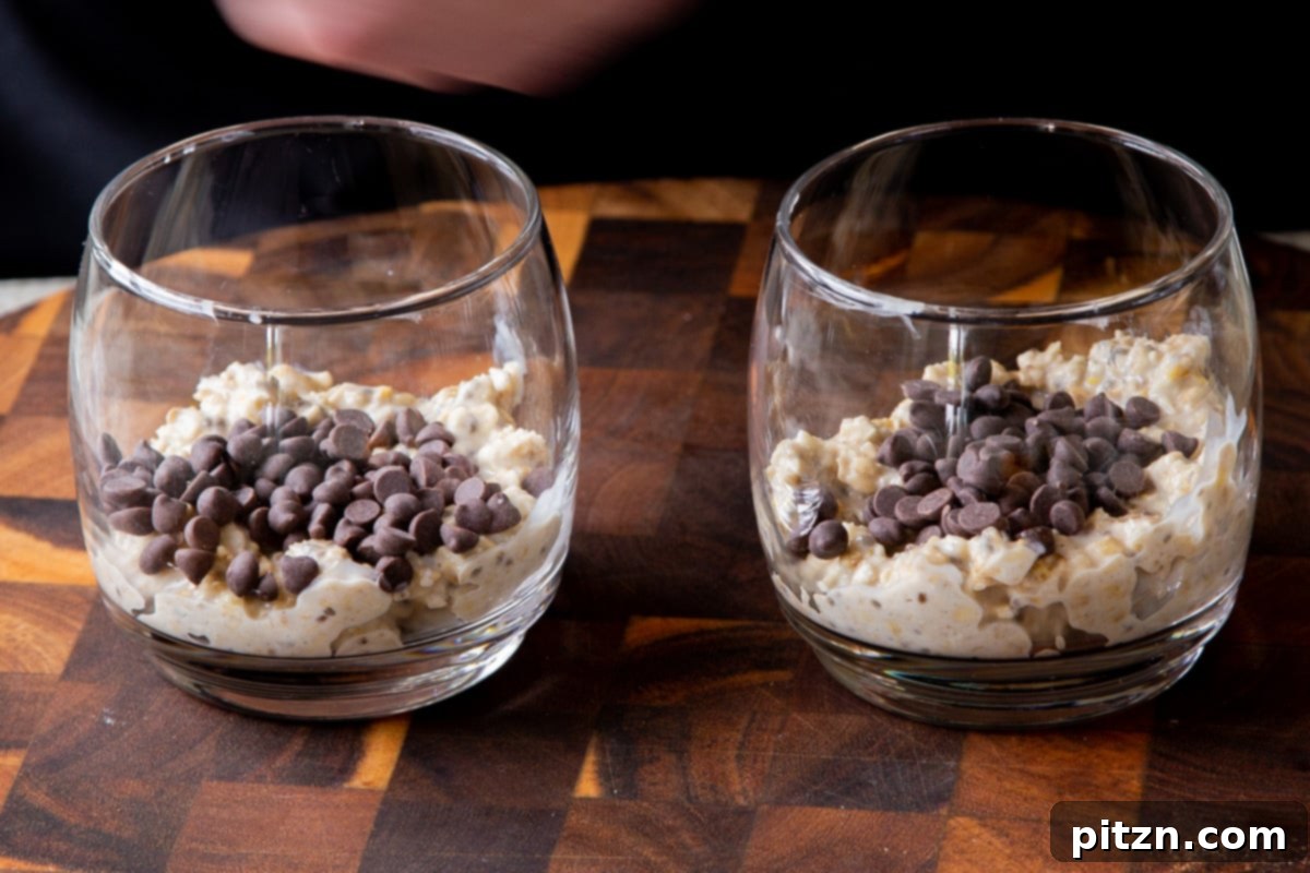 Easy Cannoli Overnight Oats: 30-Minute, Gluten-Free & Soy-Free 14 Two glass cups partially filled with the oat mixture, with a layer of vegan chocolate chips sprinkled on top.