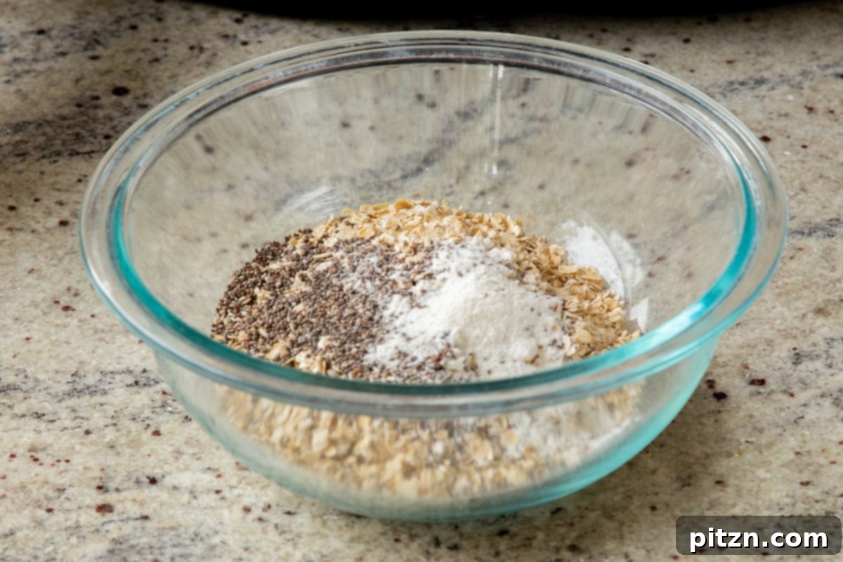 Easy Cannoli Overnight Oats: 30-Minute, Gluten-Free & Soy-Free 8 Adding chia seeds to the old-fashioned oats in a clear glass bowl on a wooden surface.