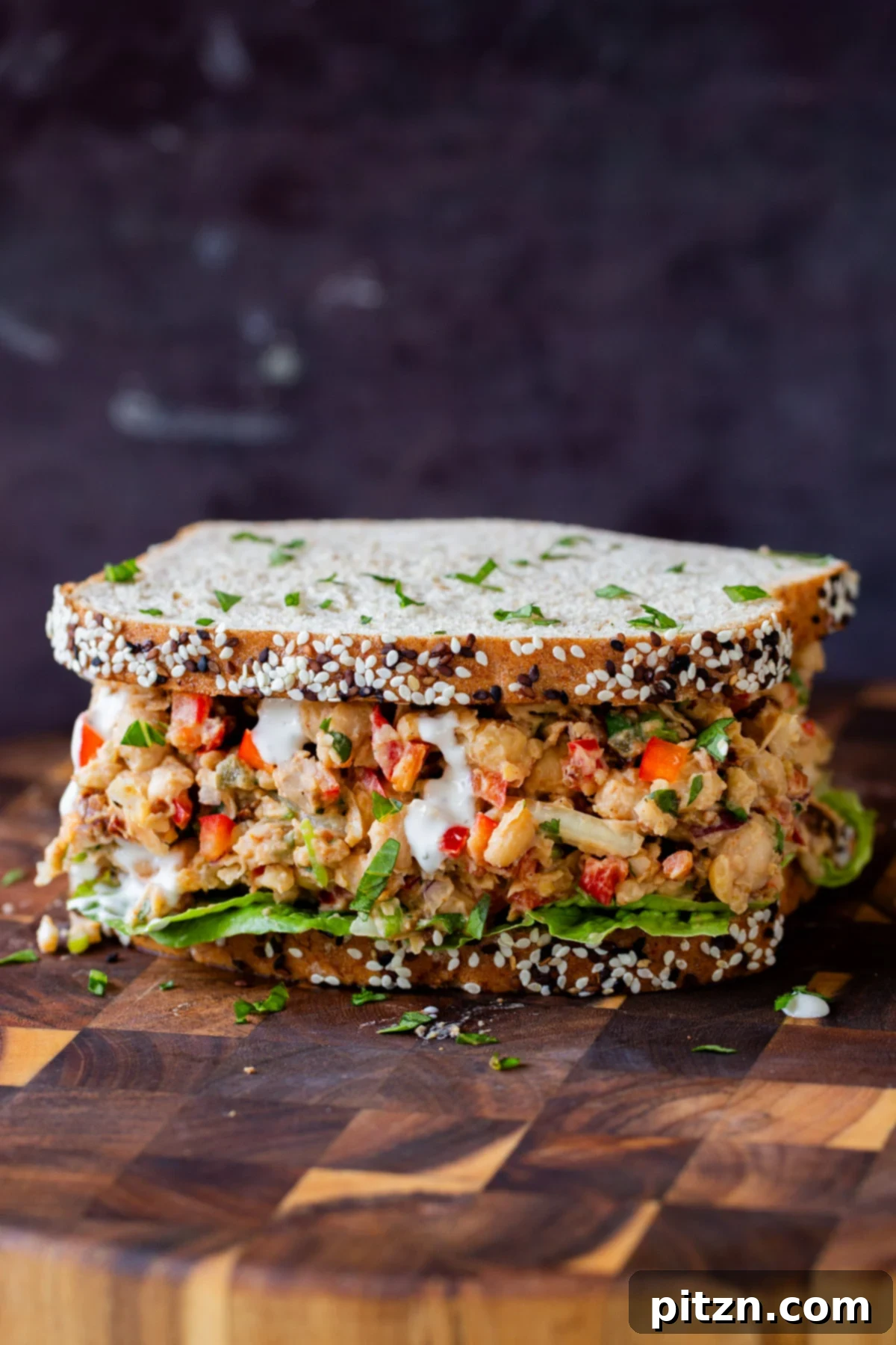 cajun chickpea salad in a sandwich with lettuce and a sprinkle of cilantro