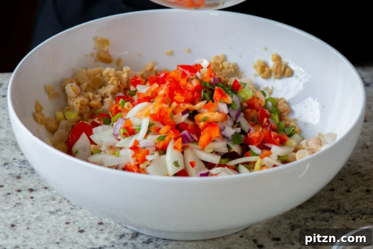 adding the crunchy veggies to the mashed chickpeas