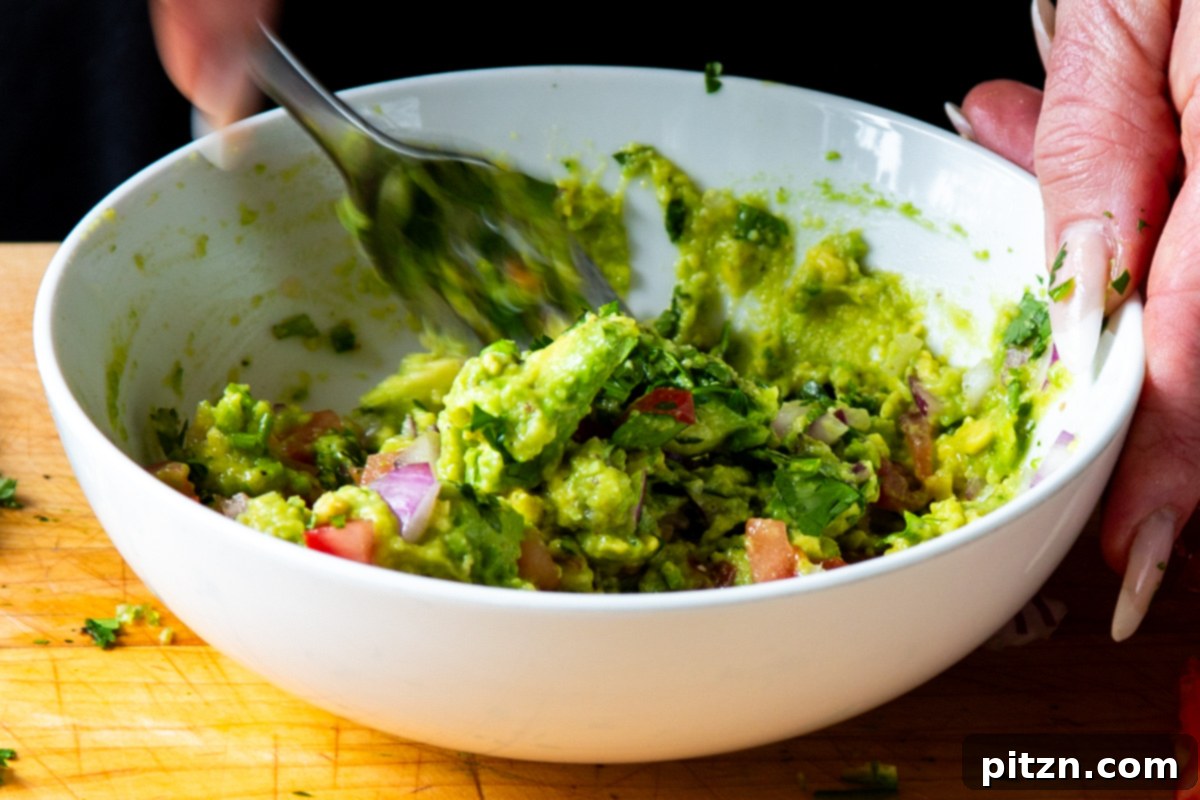 Crispy Quinoa Tacos: Effortlessly Allergy-Friendly 14 Mixing the other guacamole ingredients, like chopped onion, tomato, and cilantro, into the mashed avocado