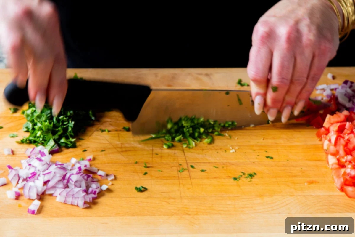 Crispy Quinoa Tacos: Effortlessly Allergy-Friendly 7 Prepping the fresh vegetables for the guacamole, showing chopped onions, tomatoes, and cilantro