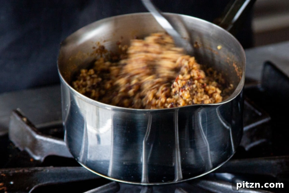 Crispy Quinoa Tacos: Effortlessly Allergy-Friendly 9 Fluffing the cooked quinoa in the saucepan after cooking on the stove, showing its light and airy texture