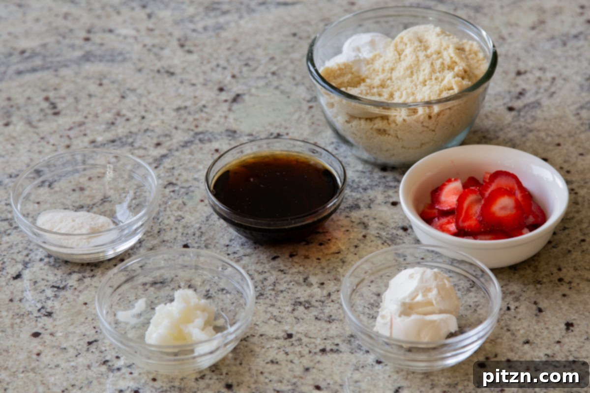 Blissful Strawberry Cheesecake Cookies Without Gluten Soy Or Grains 6 Collection of almond flour, fresh strawberries, and other cookie ingredients in various bowls on a clean kitchen counter