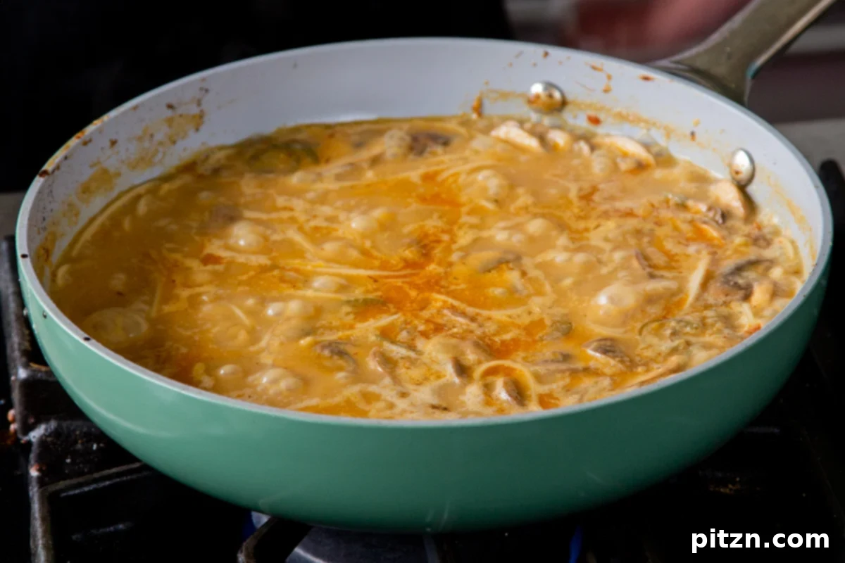 Ramen noodles being carefully added to the rapidly boiling Tonkotsu broth, ready to cook until al dente and absorb the rich flavors.