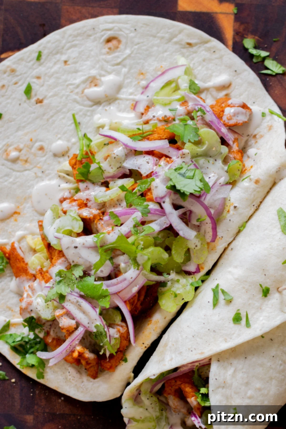 Zesty 30-Minute Cajun Buffalo Soy Curl Wraps 4 Close-up of an open Buffalo Cajun Soy Curl Wrap, revealing the juicy, flavor-packed soy curl filling, with fresh, crunchy vegetables and a creamy drizzle of vegan ranch.