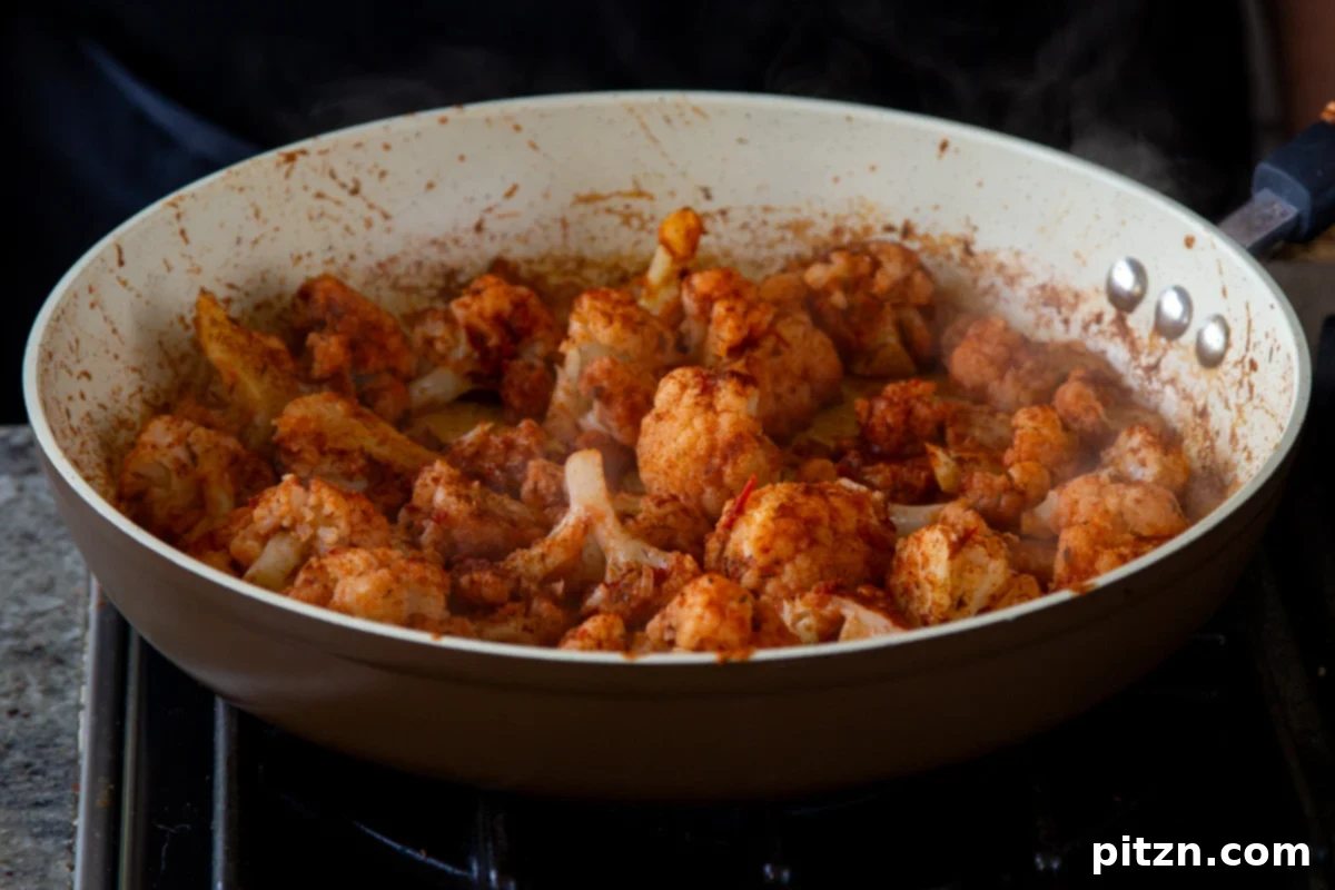 Spicy Harissa Roasted Cauliflower with Creamy Tahini Dill 10 harissa paste and spices tossed with the cauliflower in the pan, before cooking is complete