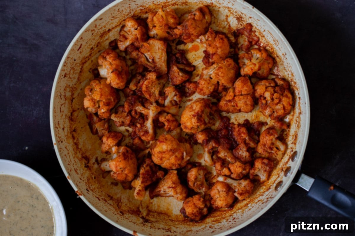 Spicy Harissa Roasted Cauliflower with Creamy Tahini Dill 11 harissa cauliflower in the pan, after cooking to caramelized perfection