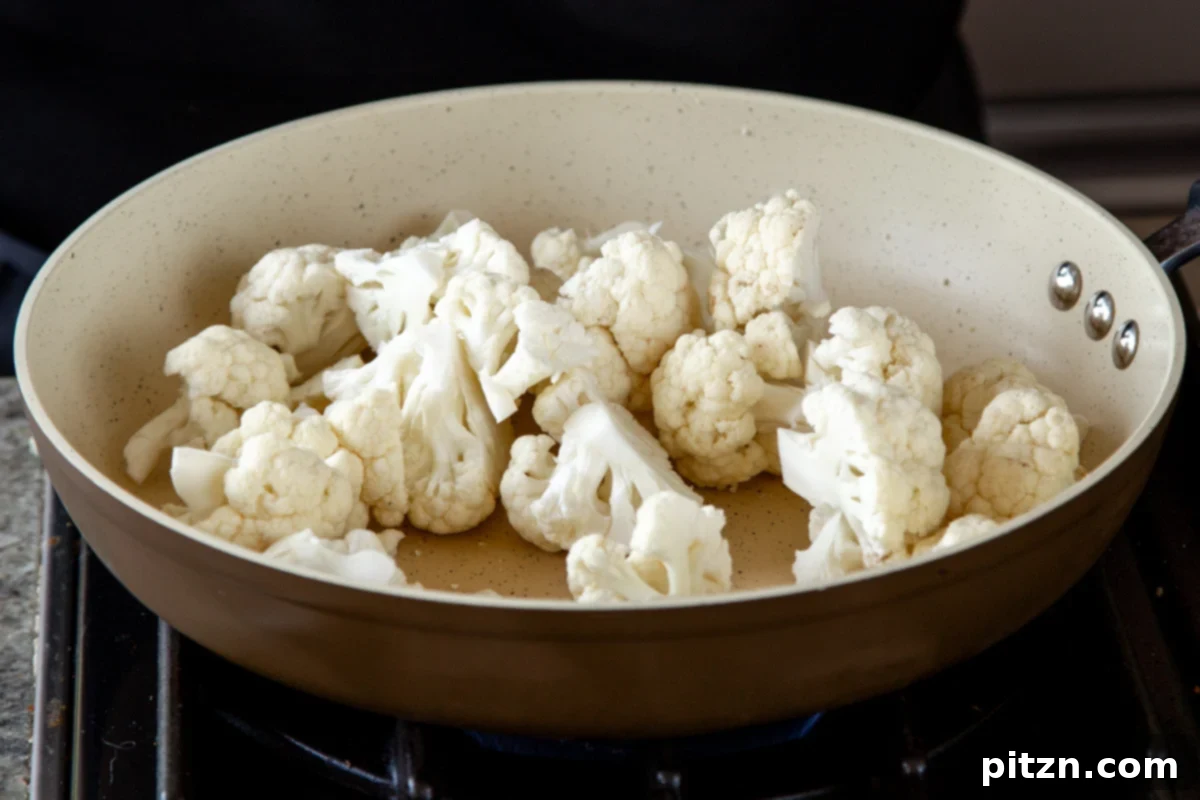 Spicy Harissa Roasted Cauliflower with Creamy Tahini Dill 8 cauliflower in the pan, before cooking, coated in a rich harissa marinade