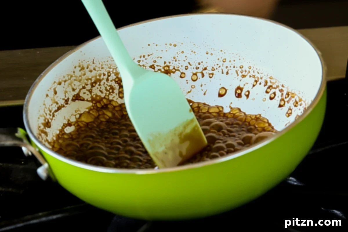 Coffee-caramel syrup bubbling and thickening in a pan, indicating it's nearly ready for the Tiramisu Cookies.