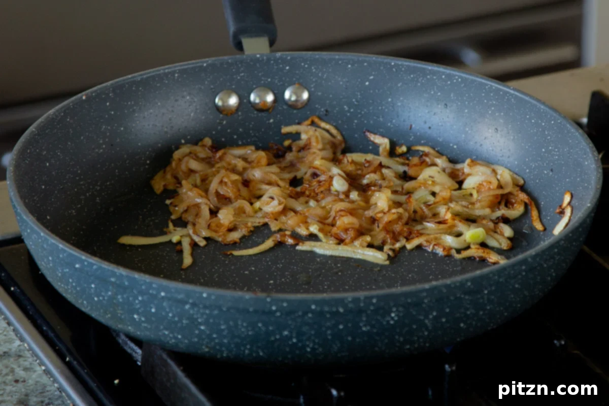Onions, after browning to a deep golden color in the pan, forming a sweet and savory base.