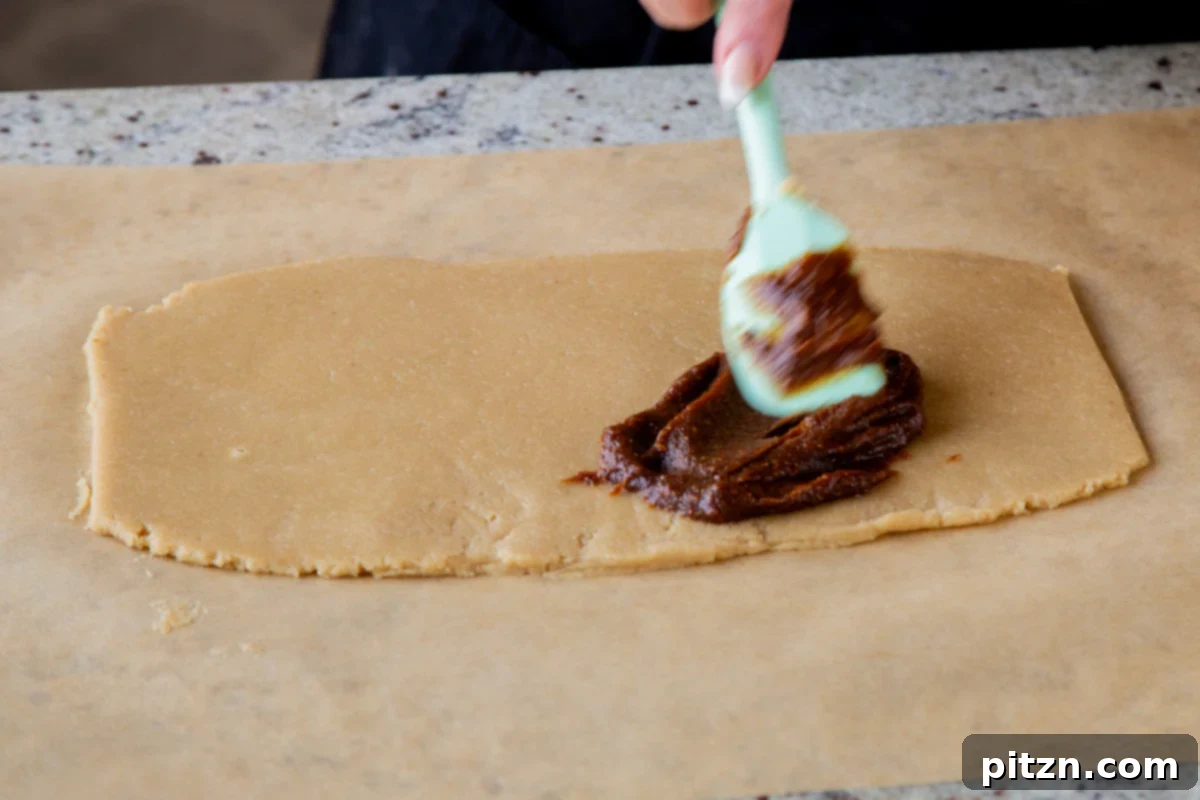 spreading the pumpkin pie spice mixture onto the rolled out almond flour cookie dough evenly