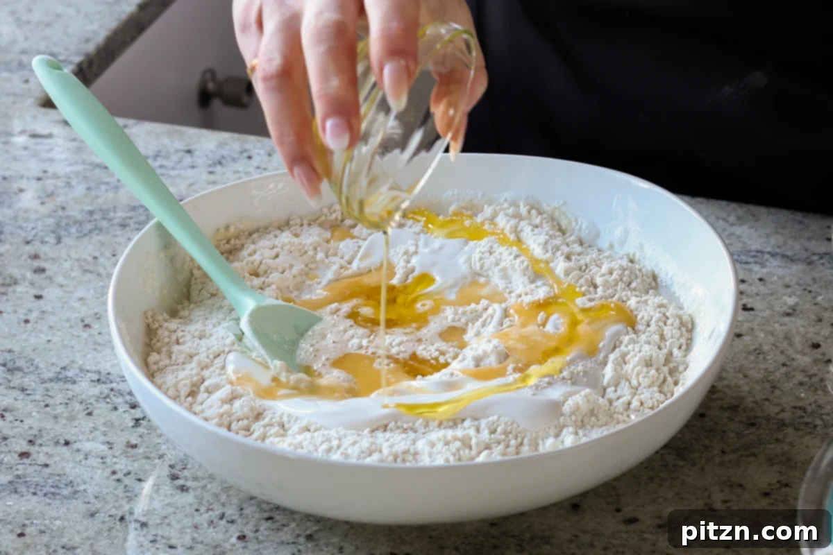 Melt-in-Your-Mouth Dinner Rolls 12 adding melted vegan butter and oil to the dough