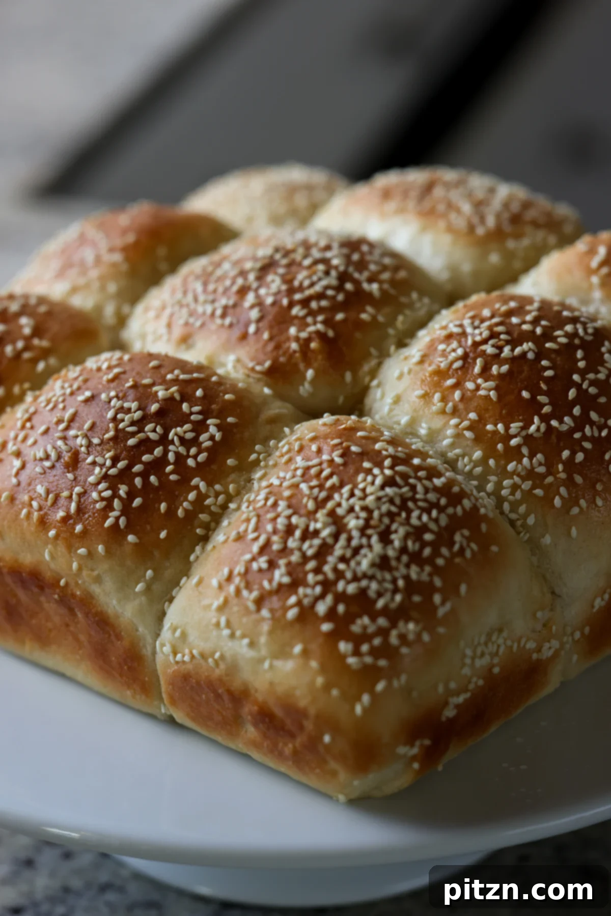 Melt-in-Your-Mouth Dinner Rolls 4 fluffy dinner rolls on a serving tray before pulling apart