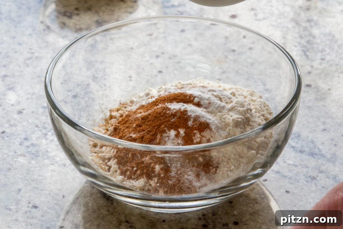 adding flour and spices to the bowl of oats