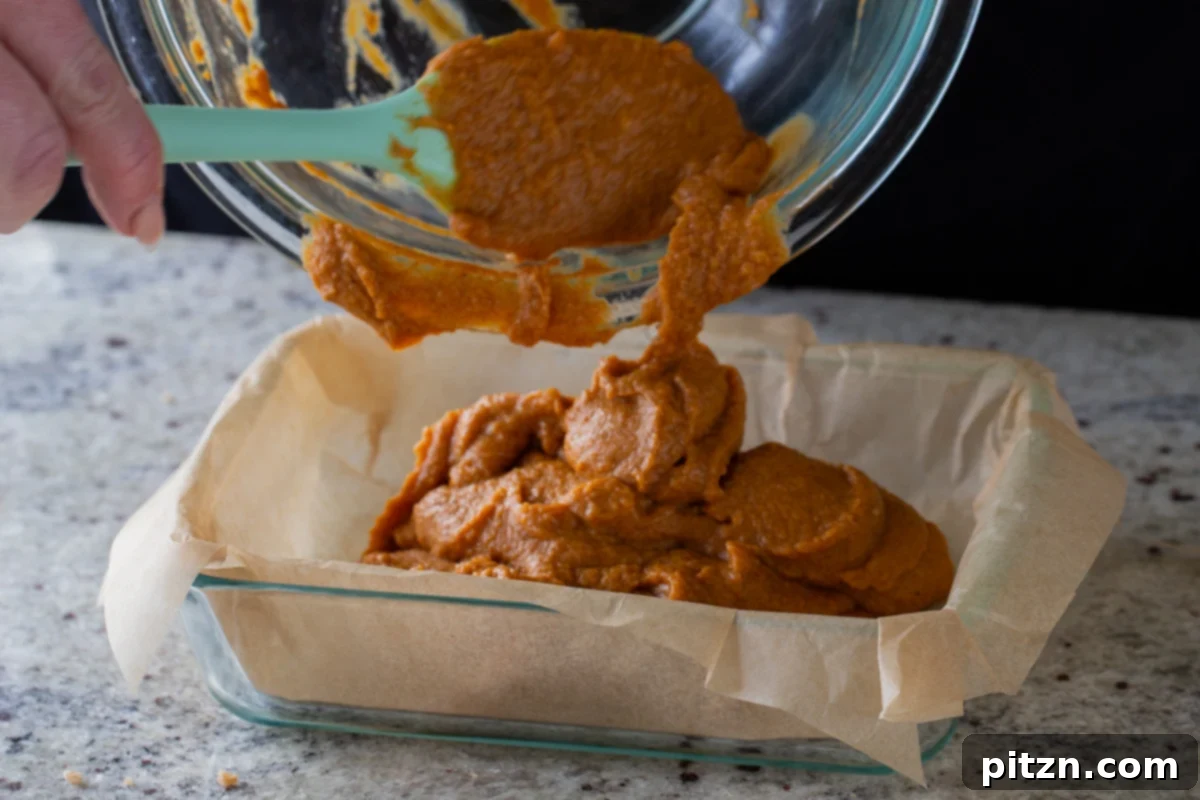 transferring pumpkin crisp filling to the lined baking pan