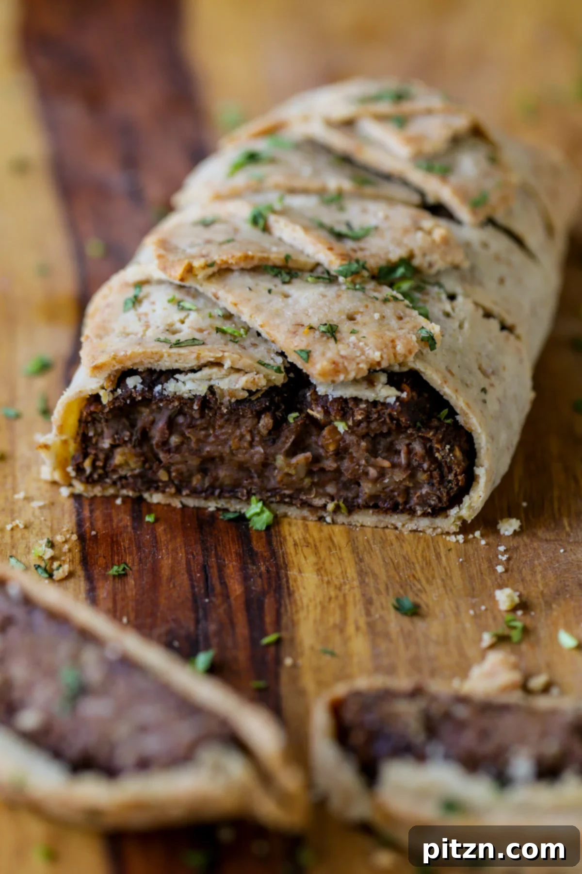 Ultimate Gluten-Free Vegan Wellington 2 Sliced Gluten-Free Vegan Wellington on a cutting board, showcasing its rich filling and golden crust, ready to be served with gravy.