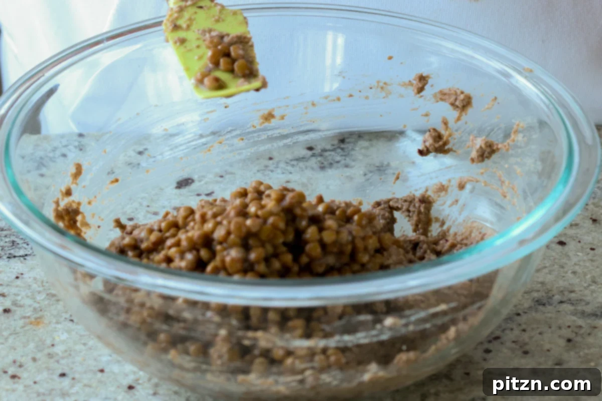 Ultimate Gluten-Free Vegan Wellington 15 Whole lentils being added to the blended lentil mixture, contributing to the loaf's texture and hearty appeal.