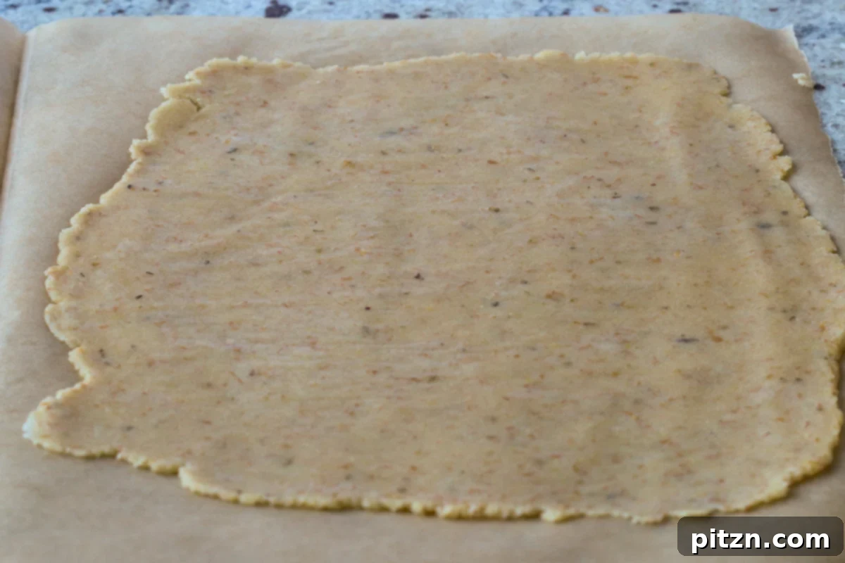 Ultimate Gluten-Free Vegan Wellington 25 The gluten-free dough after being rolled out between two sheets of parchment paper, forming a thin rectangle.