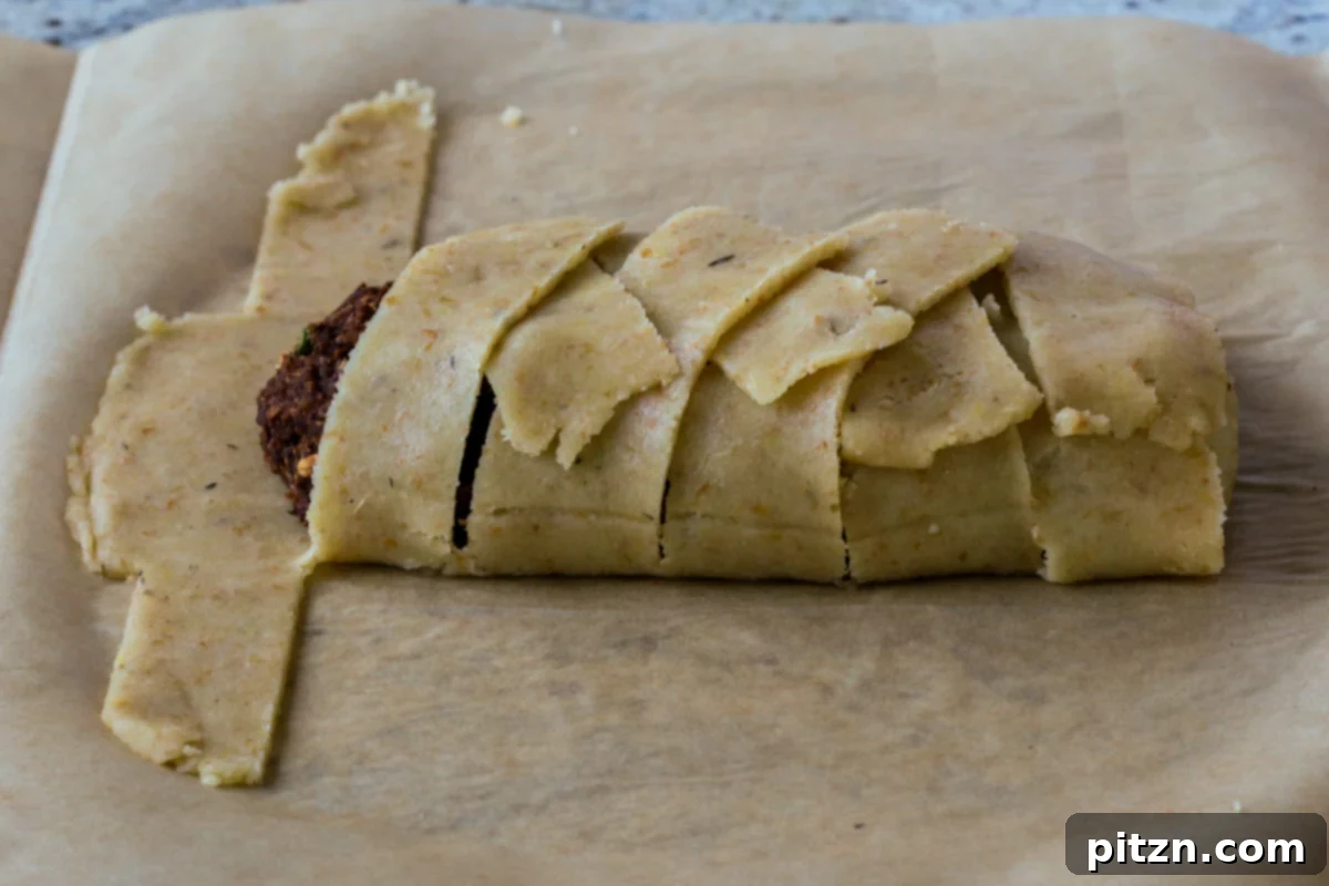 Ultimate Gluten-Free Vegan Wellington 29 The lentil loaf almost completely wrapped in the gluten-free pastry dough, showing the intricate design of the crust.