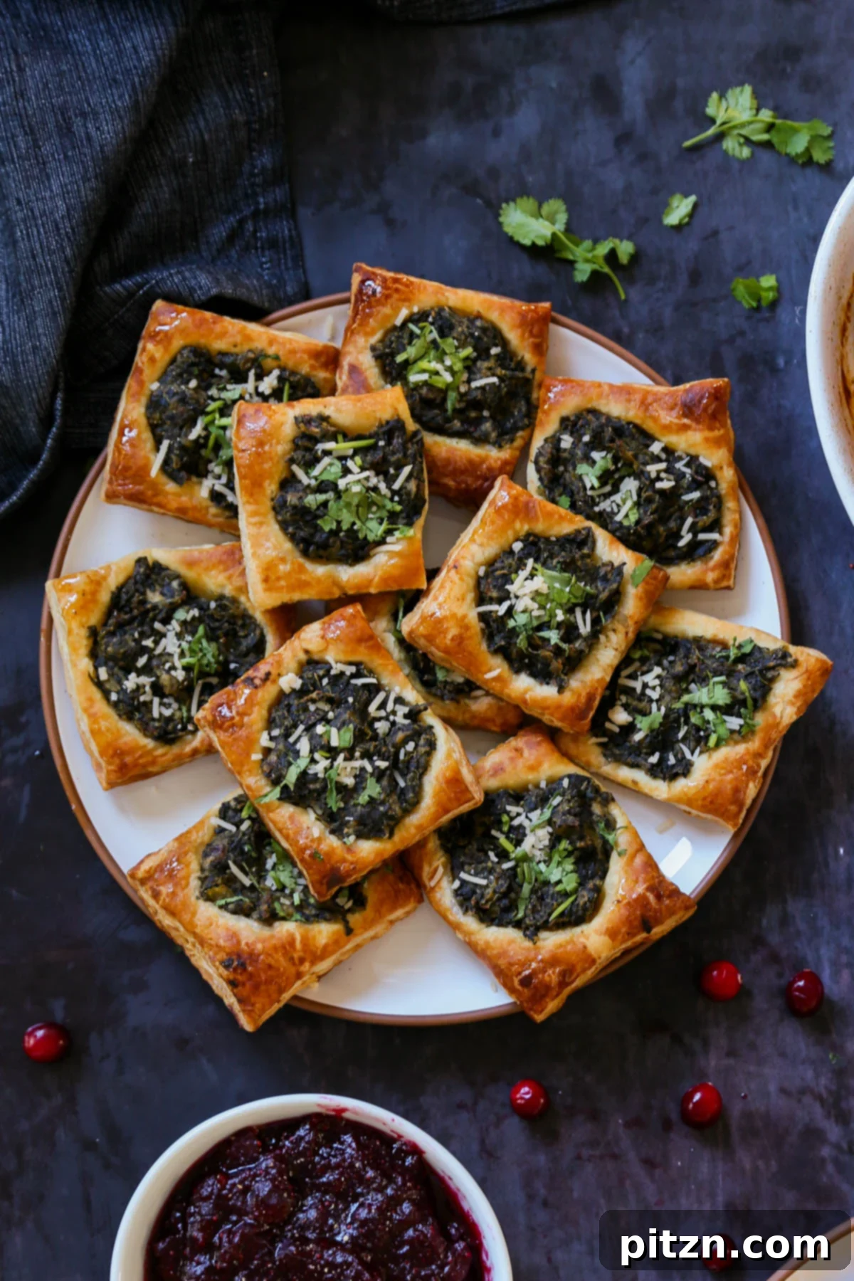 A stunning close-up of a single Indian-spiced spinach puff pastry, highlighting its golden, flaky crust and creamy, vibrant spinach filling, ready to be served.