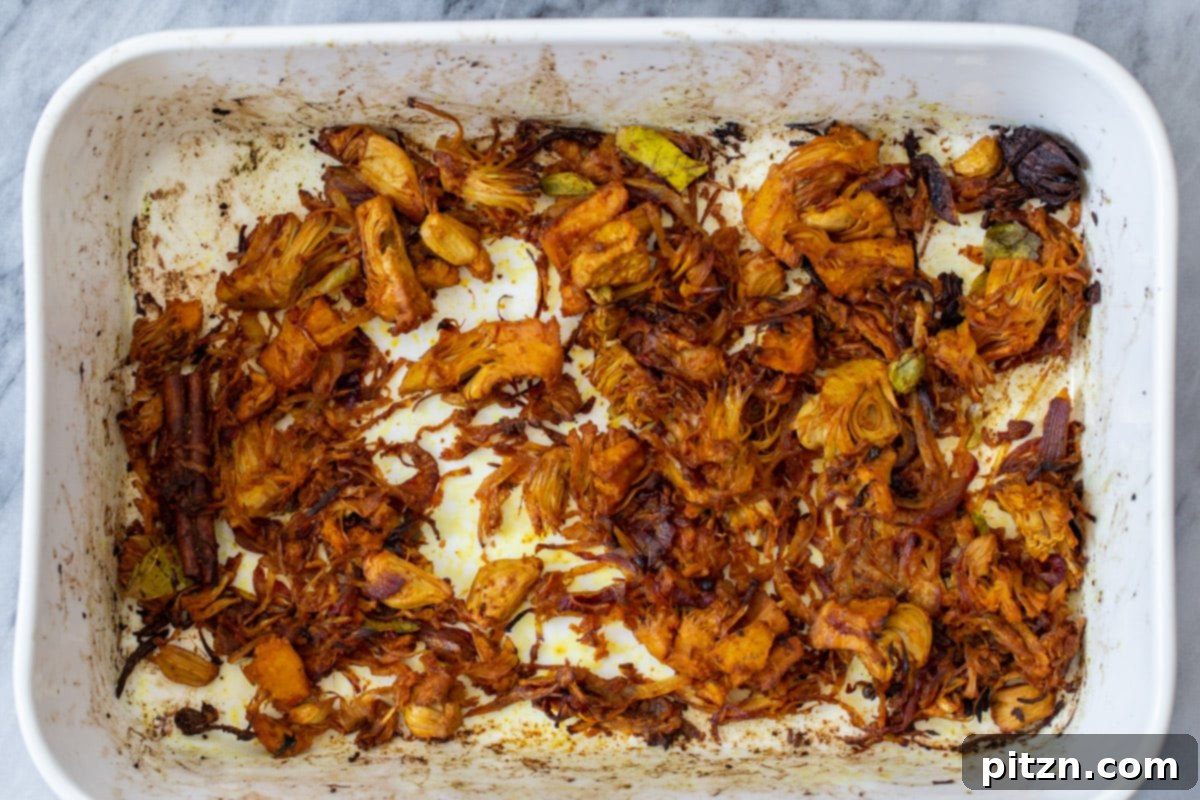 Golden brown jackfruit and caramelized onions in the baking dish after the first bake.