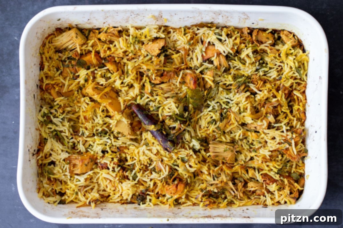 Fluffy and aromatic baked jackfruit biryani in the pan after being stirred and fluffed.