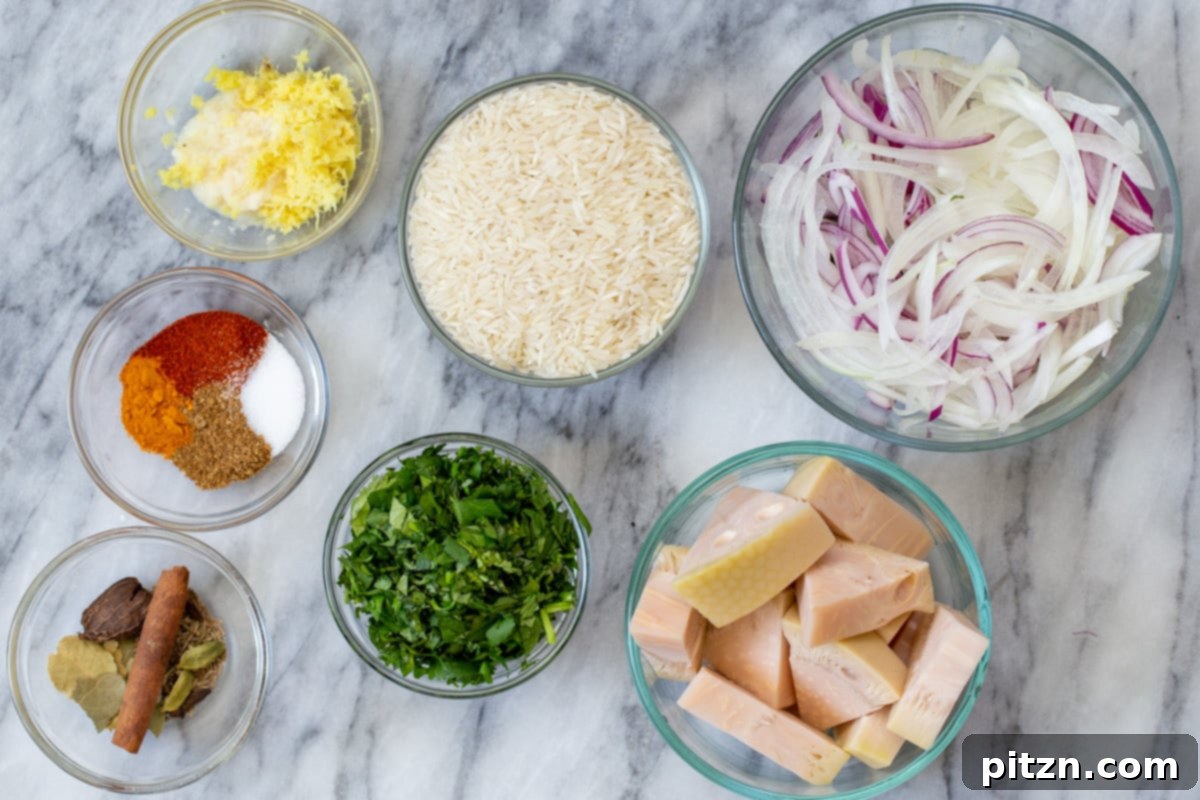 A selection of ingredients for vegan biryani, including Basmati rice, jackfruit, and fresh herbs, arranged on a kitchen counter.
