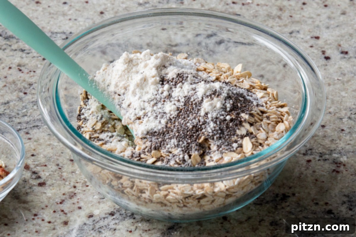 Cozy Baked Oatmeal Gift Mix 10 All-purpose flour and chia seeds being added to the dry oats mixture, enhancing binding and nutritional value.