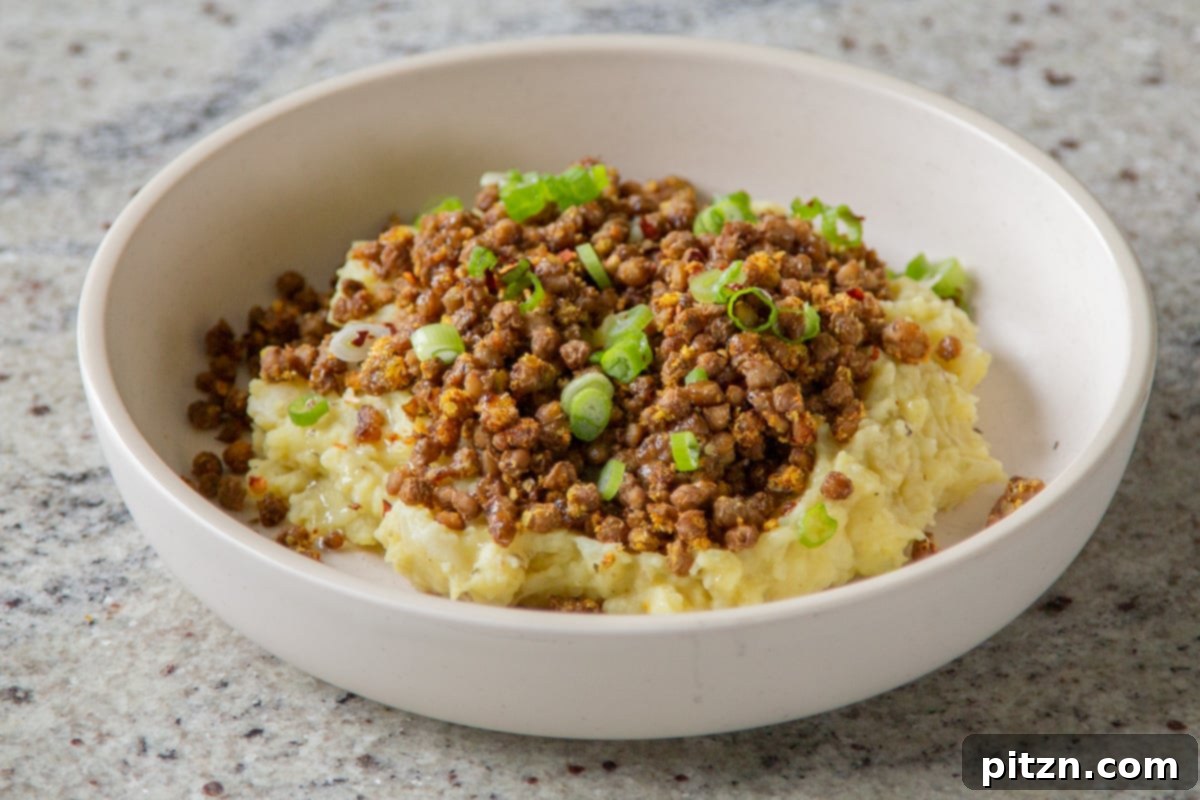 Popped Lentils and Whipped Potatoes 17 A final close-up of the finished lentil mashed potatoes in a bowl, garnished with green onions and a drizzle of olive oil, ready to be enjoyed.