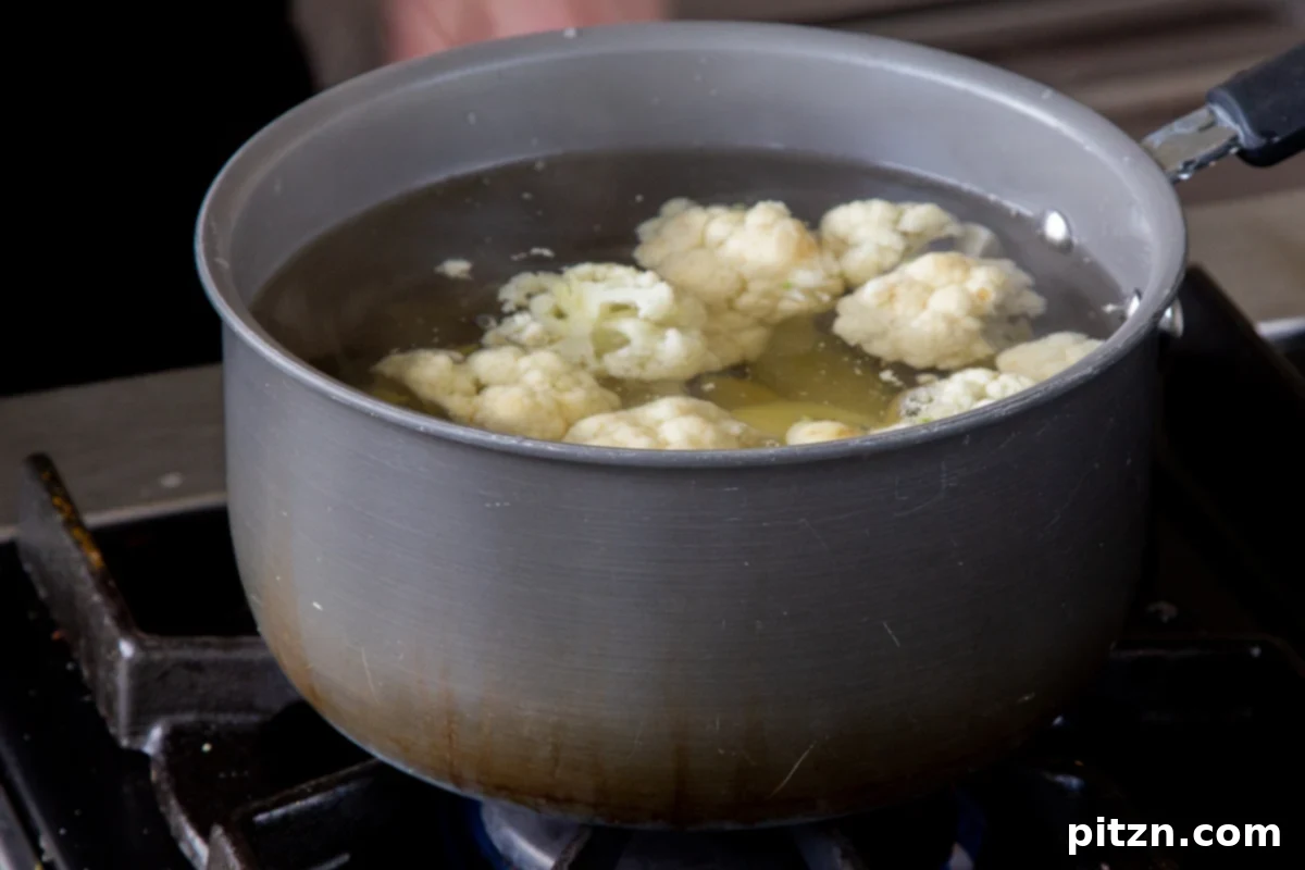 Popped Lentils and Whipped Potatoes 6 Cauliflower florets and cubed potatoes cooking in a pot on the stovetop, ready for mashing.