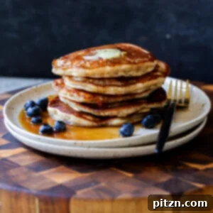 Stack of gluten-free lemon blueberry pancakes on a plate with blueberries