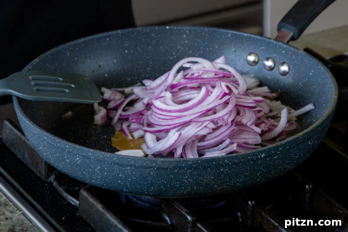 South Indian Black Pepper Tofu Fry 14 Adding sliced red onion to the pan with whole spices
